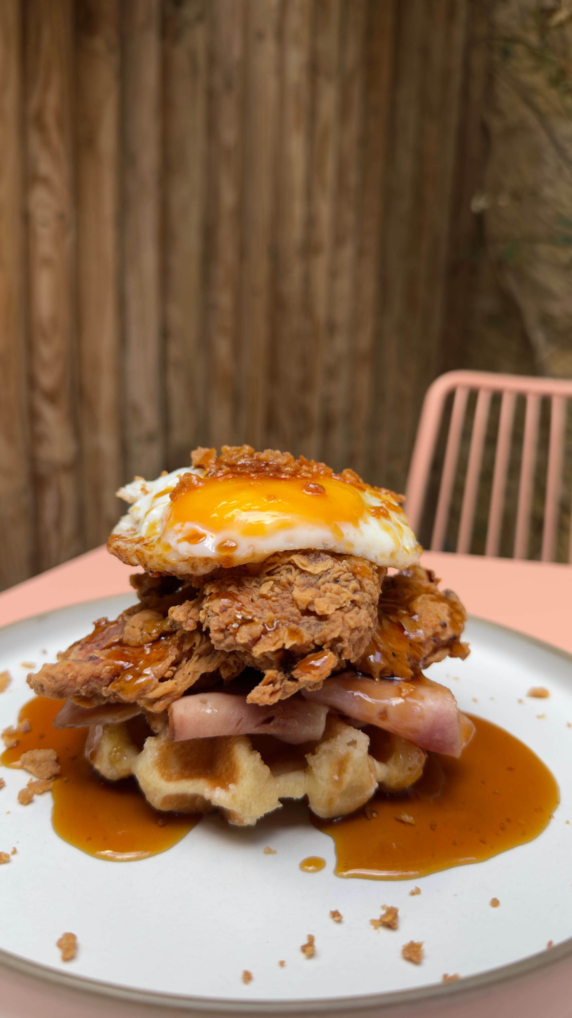 Waffle topped with buttermilk fried chicken, bacon and a fried egg