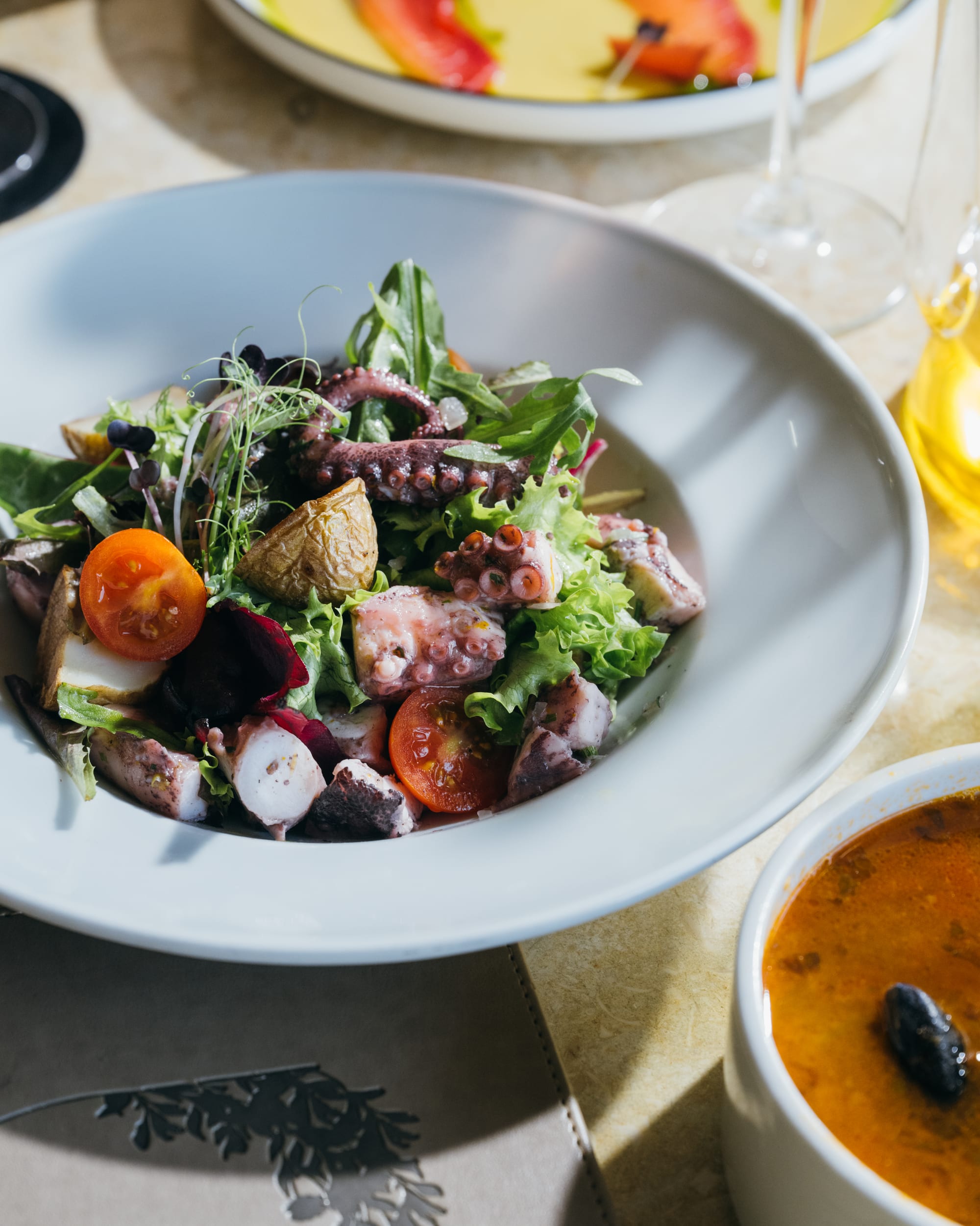 Octopus salad with potatoes, tomatoes and leaves